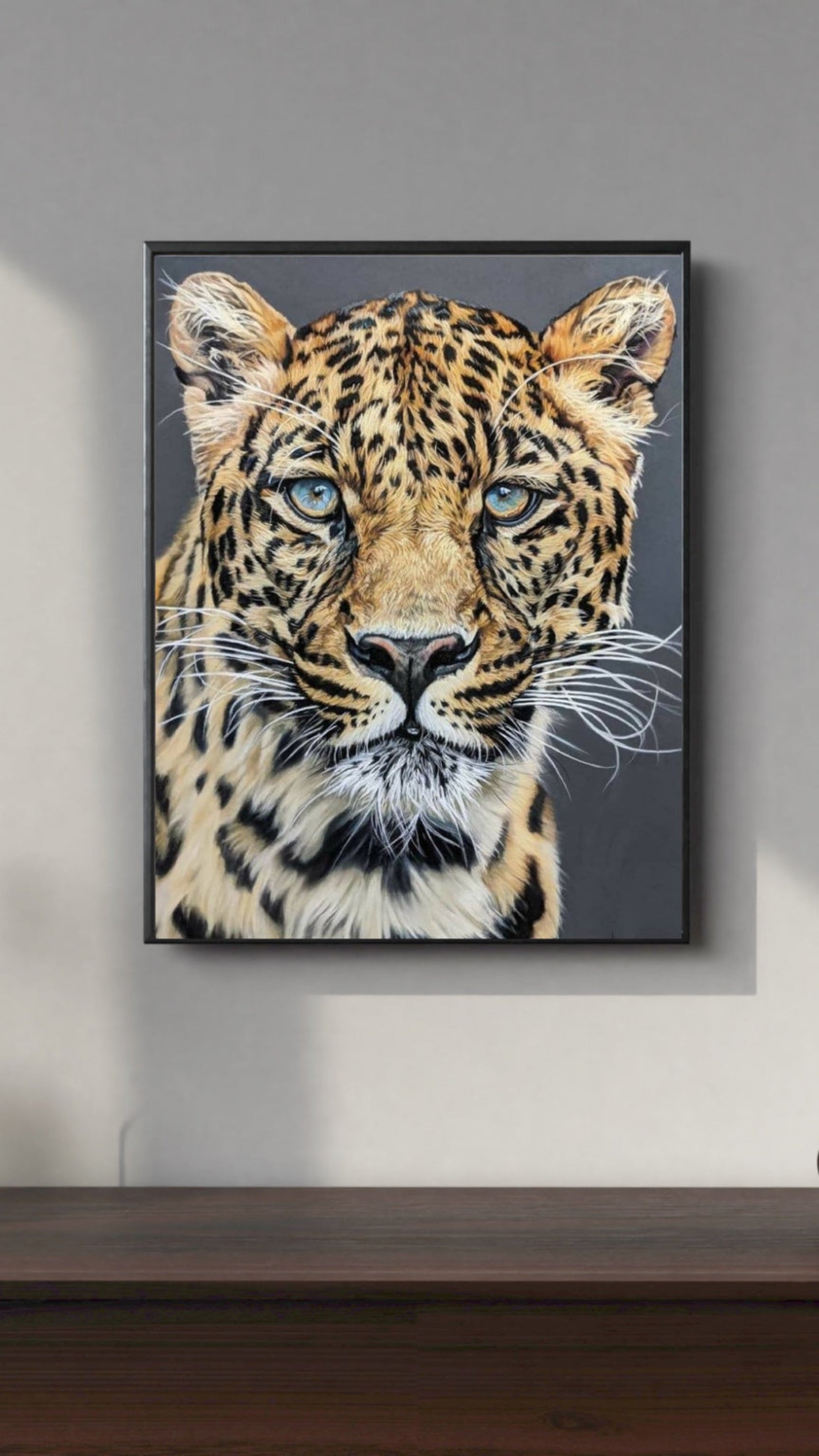 Framed artwork of a leopard on a gray wall